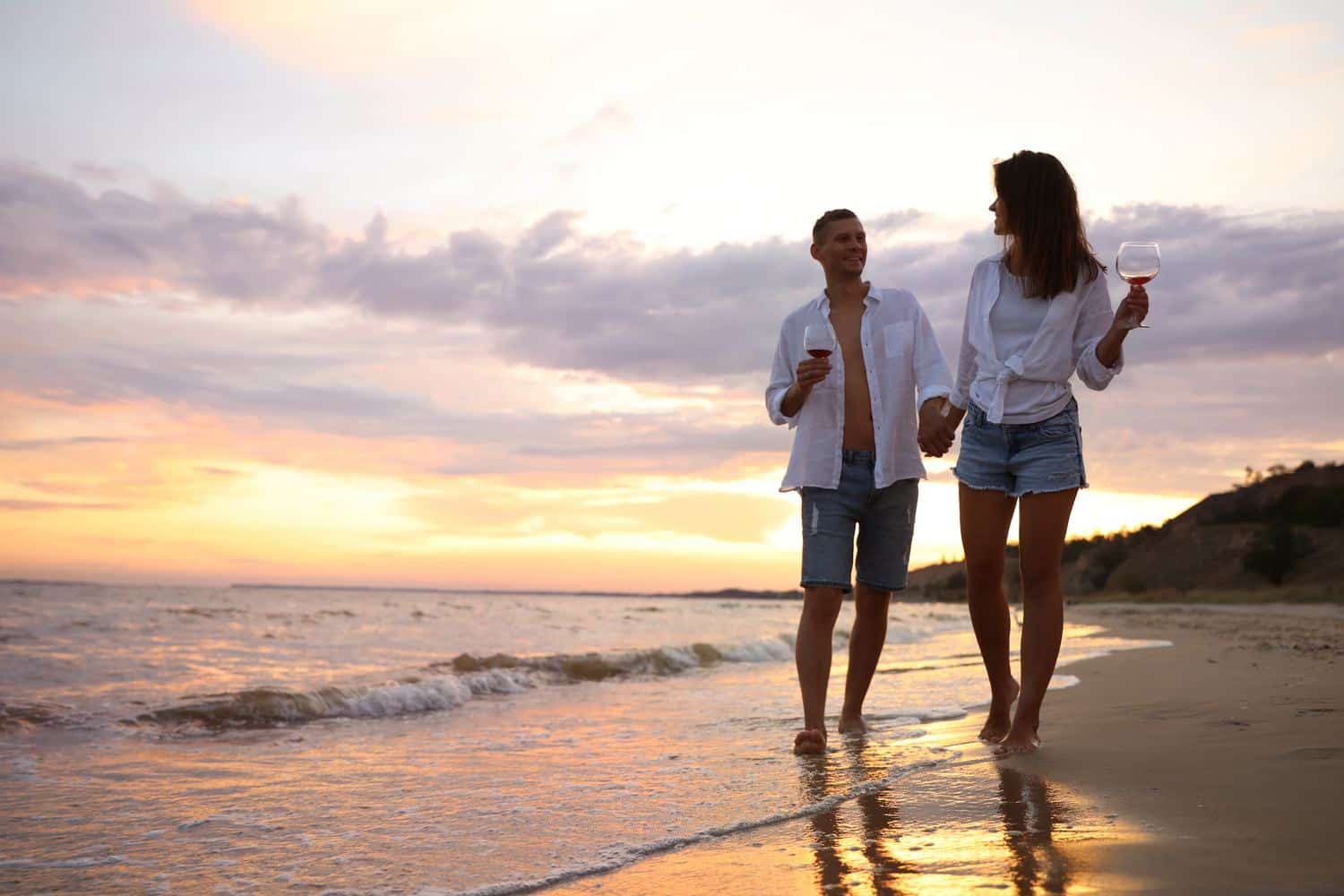 Couple en promenade sur la plage au coucher du soleil