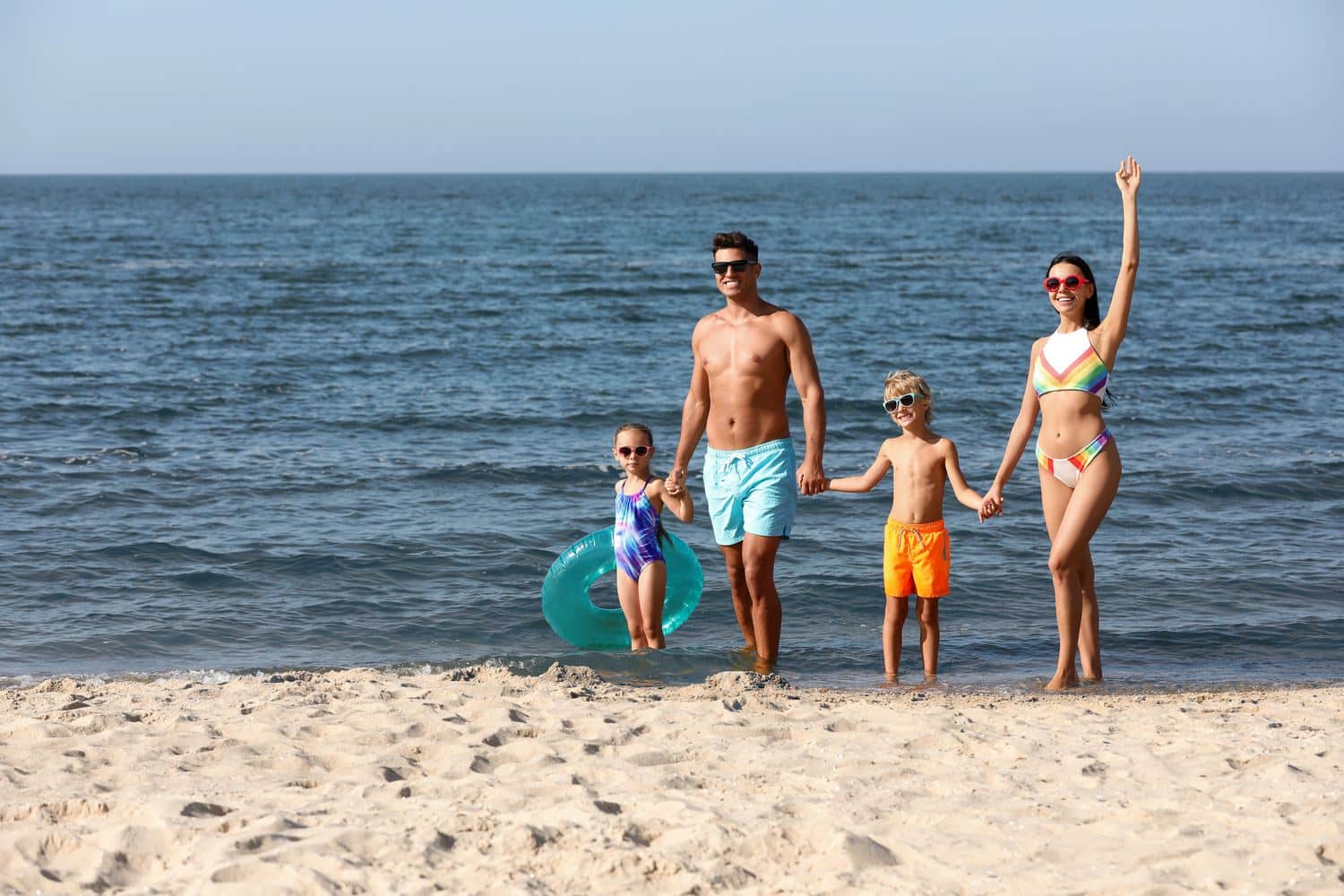 Famille prête pour la baignade sur une plage de sable en été